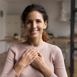 Head shot portrait smiling woman folded hands on chest